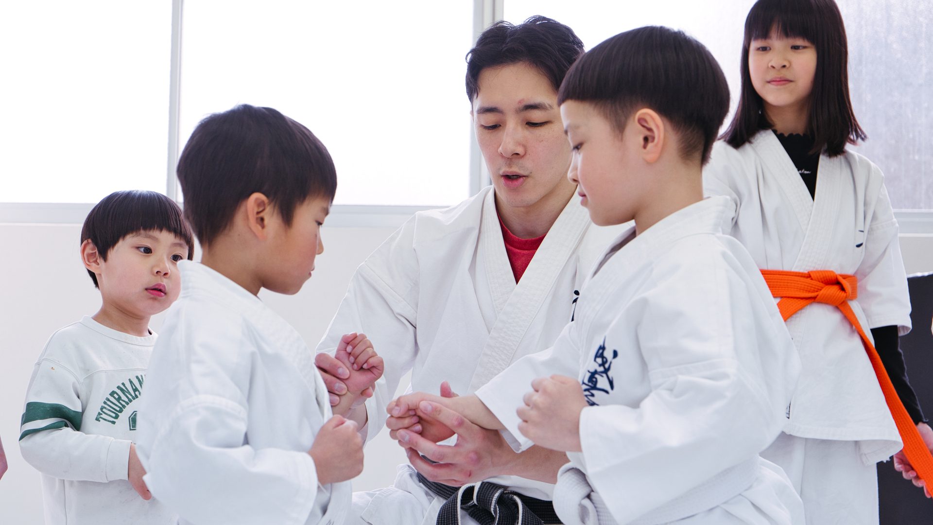 指導員が子どもたちに拳の握り方を教える様子